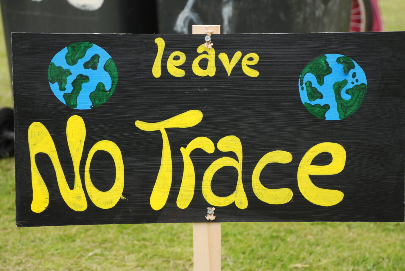 A hand-painted sign that says Leave No Trace and has two illustrations of earth.
