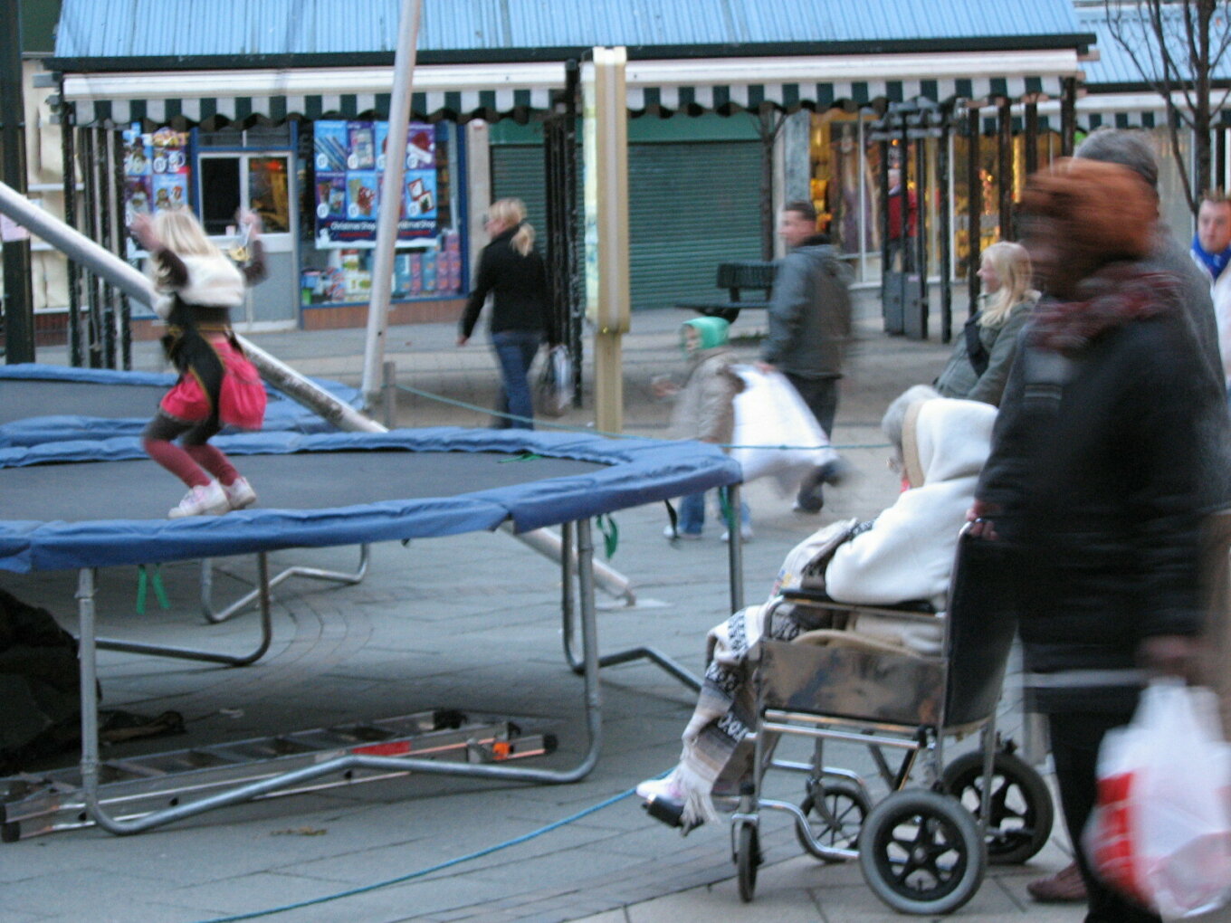 People, including a disabled woman, watching children on trampolines on Fargate
