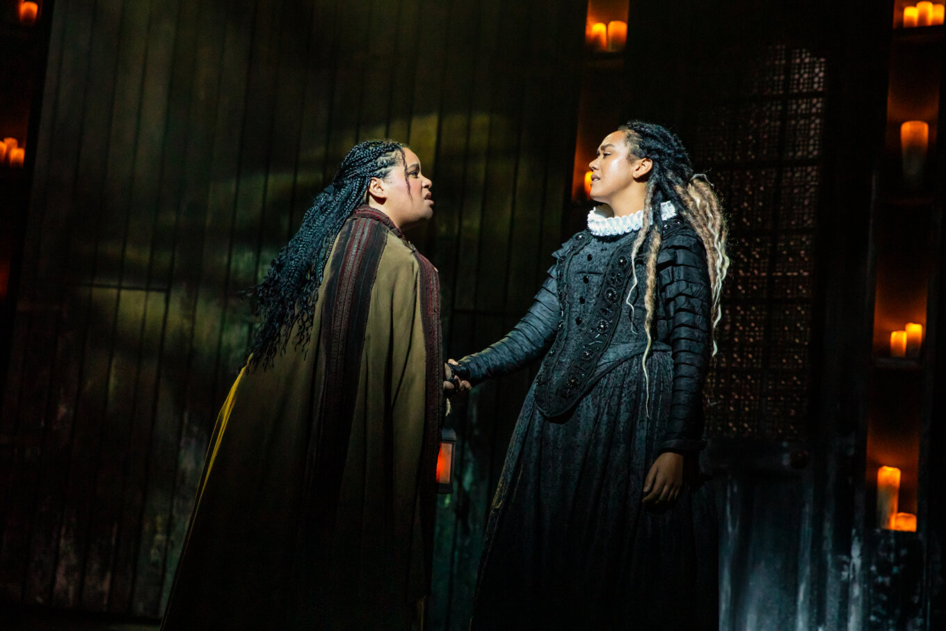 Two long-haired women, who look like they're in a confrontation, on a stage.