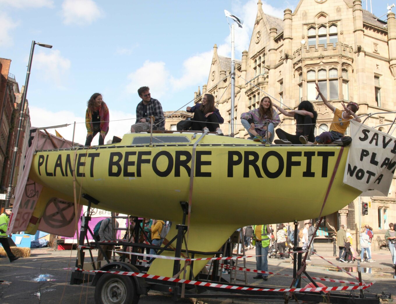The words 'Planet Before Profit' written across a boat located at the Extinction Rebellion Deansgate occupation in Manchester, 2019