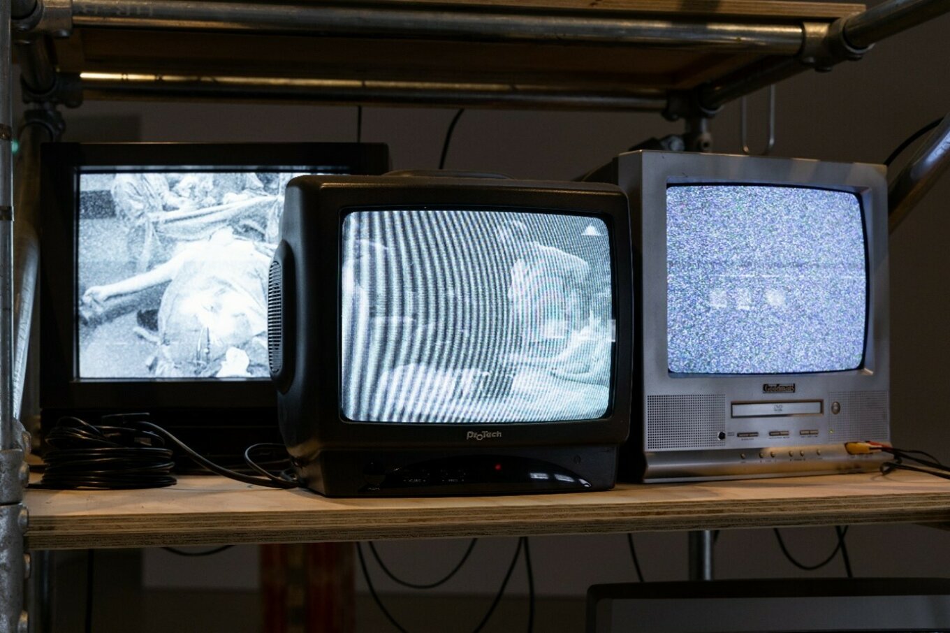 Three television sets on a shelf