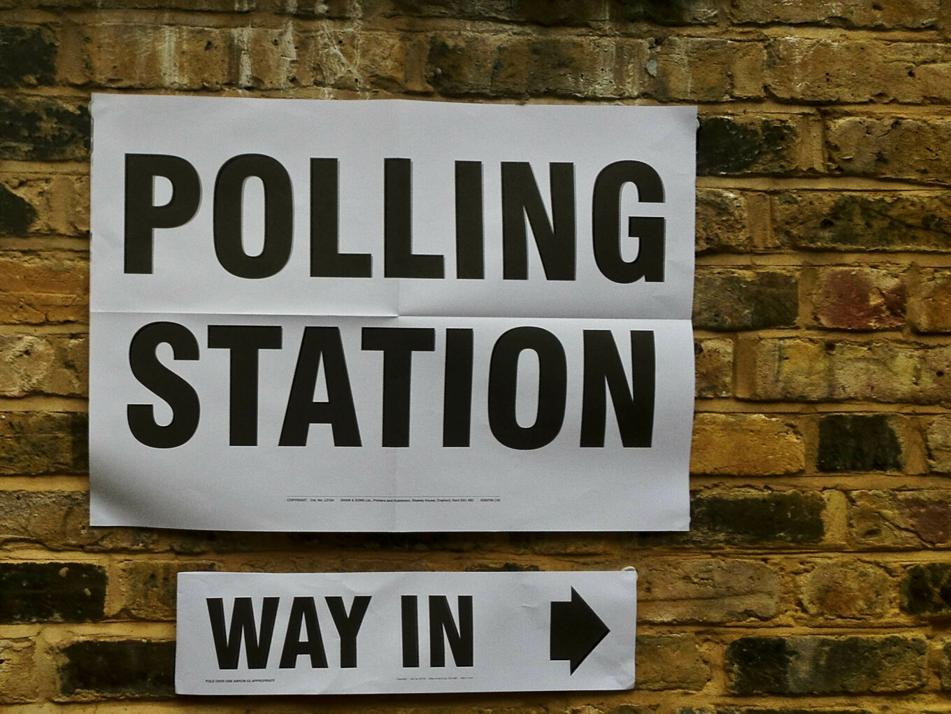 A brick wall with a Polling Station sign