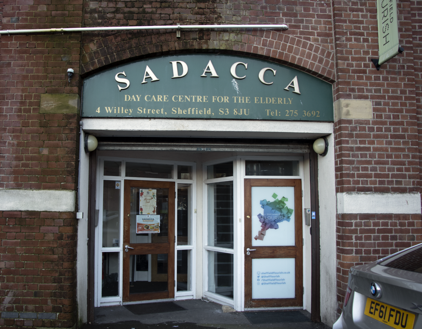 A brick building with SADACCA over the doors