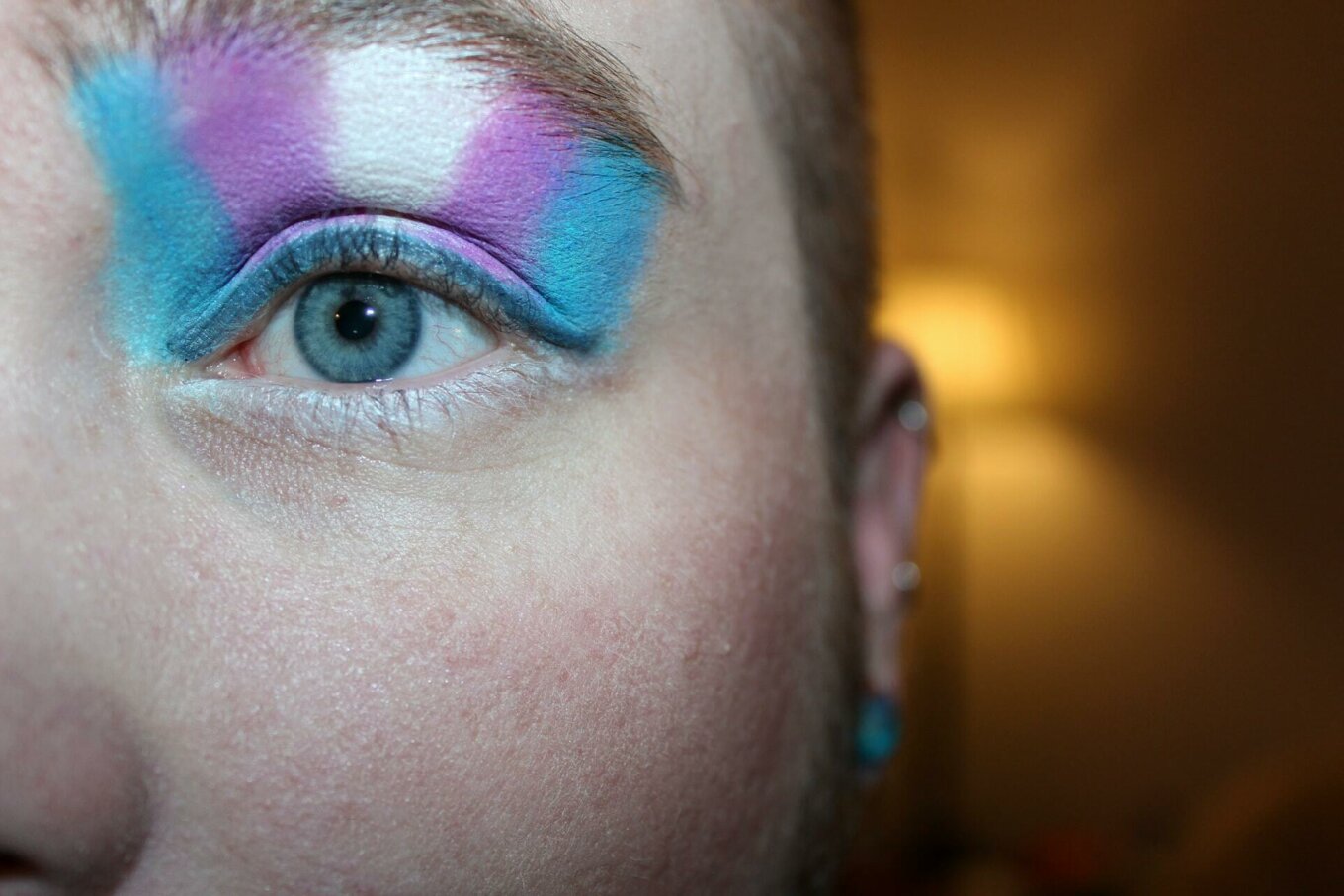 A person with eyeshadow in the colour of the trans pride flag