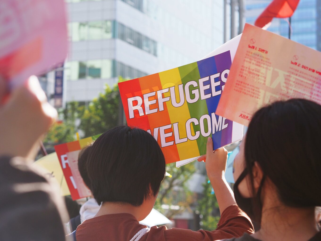 Protestors hold a sign saying "refugees welcome"