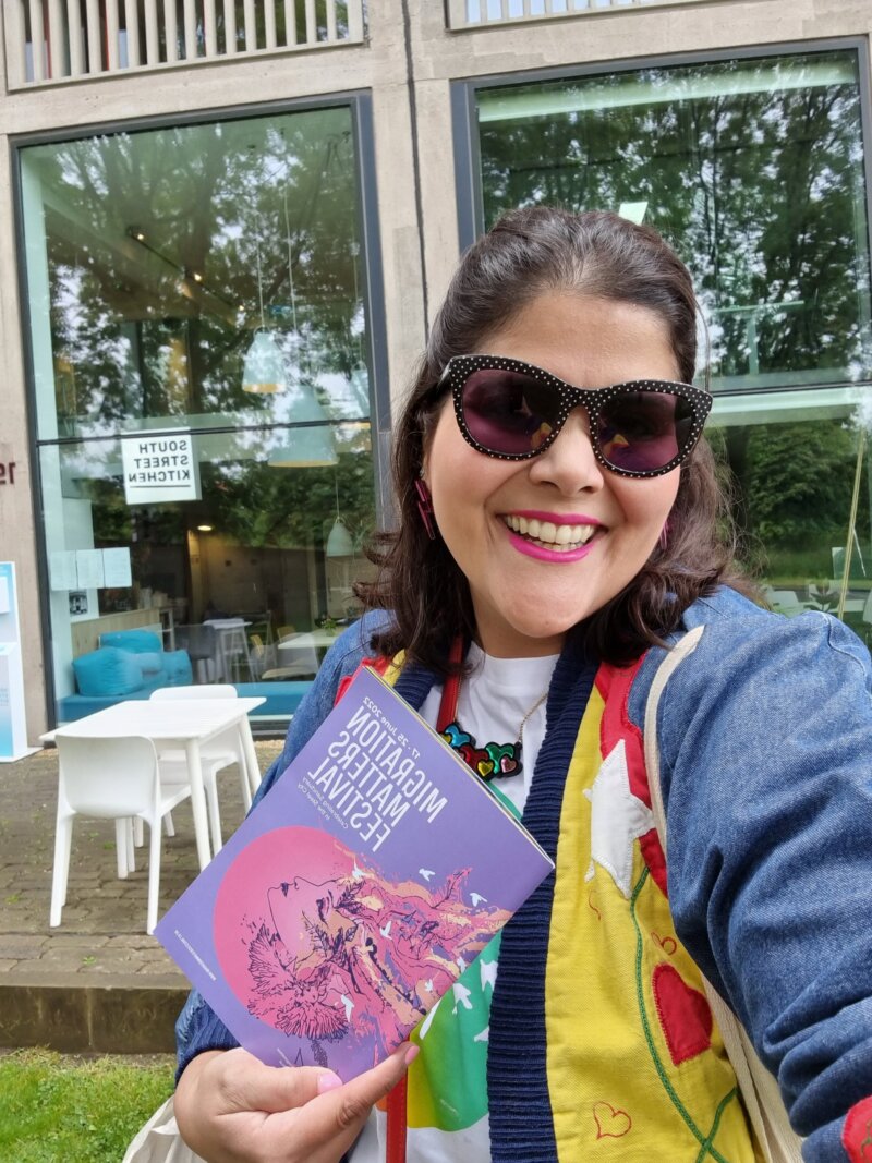 Livia Barreira with the brochure for the Migration Matters Festival 2022